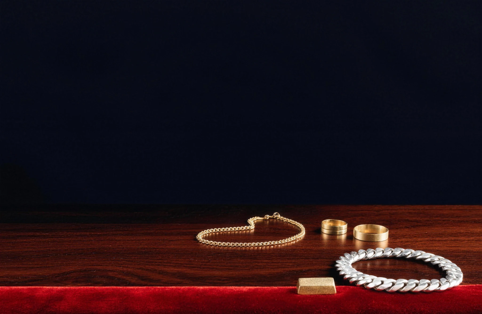 Gold rings, chain, silver bracelet and gold ingot on a valuation counter